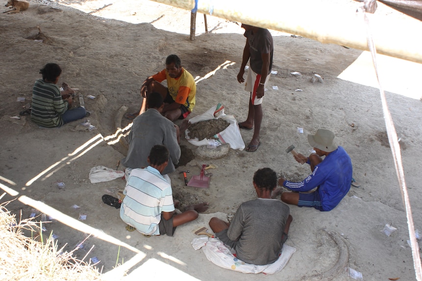 Workers sitting around the archaeological site.